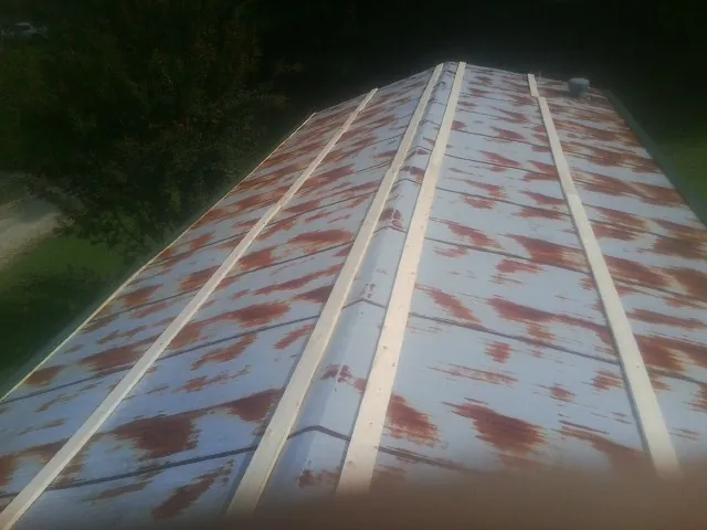 Rusted metal roof panels with new wood purlins before replacement — Storm Damage Roof Repair in Spring Grove by Roofing Brothers